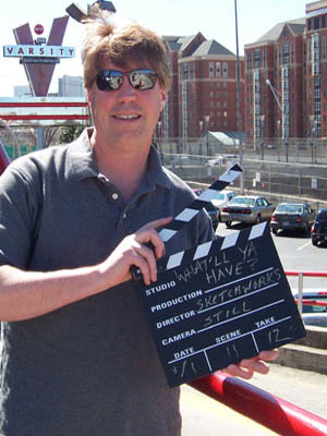 Mike Stiles holding clapboard in reference to organic content in the form of branded podcasts