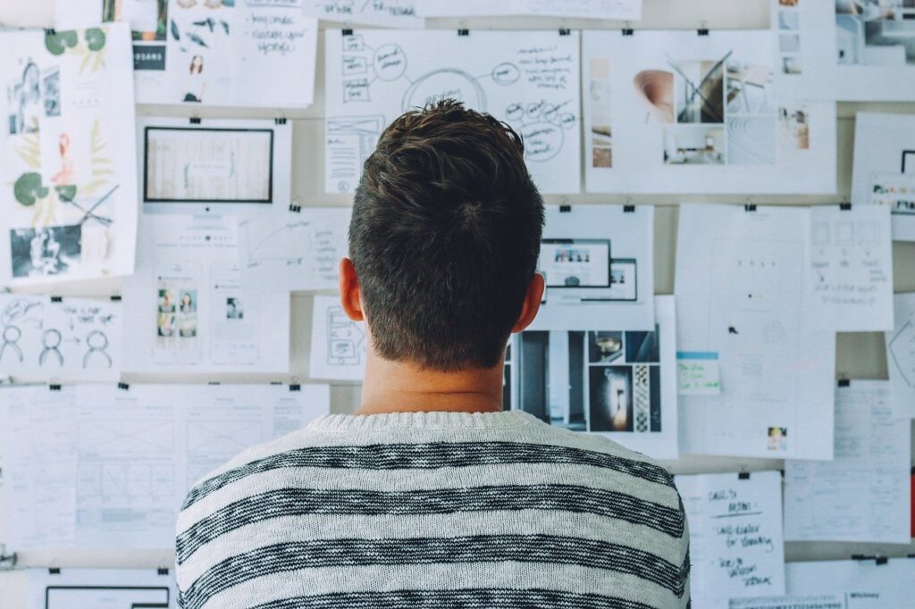 Guy looking at a content strategy pinned up on a whiteboard