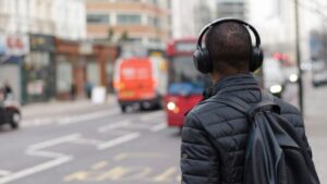 Person listening to a branded podcast through headphones on the street