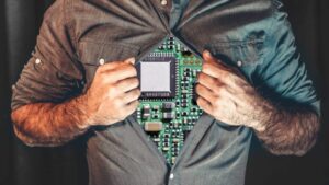 Guy opening shirt to reveal a circuit board chest, illustrating how AI is forming the identities of executive thought leaders. 