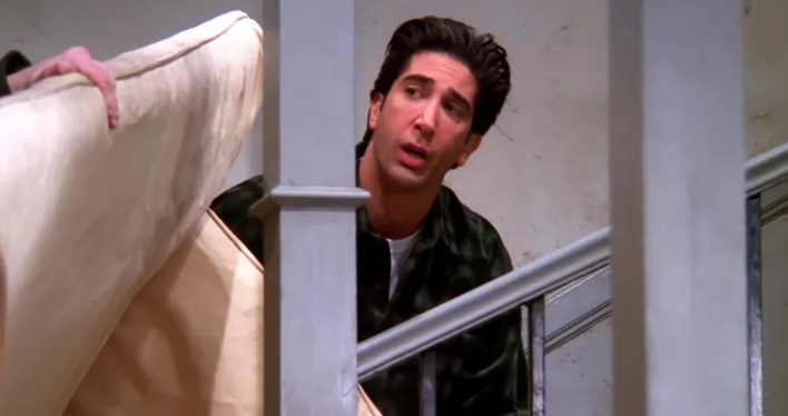 Actor carrying couch upstairs
